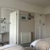 Gwyndra House B&B in St. Austell bedroom with twin beds, dresser, and en suite bathroom door