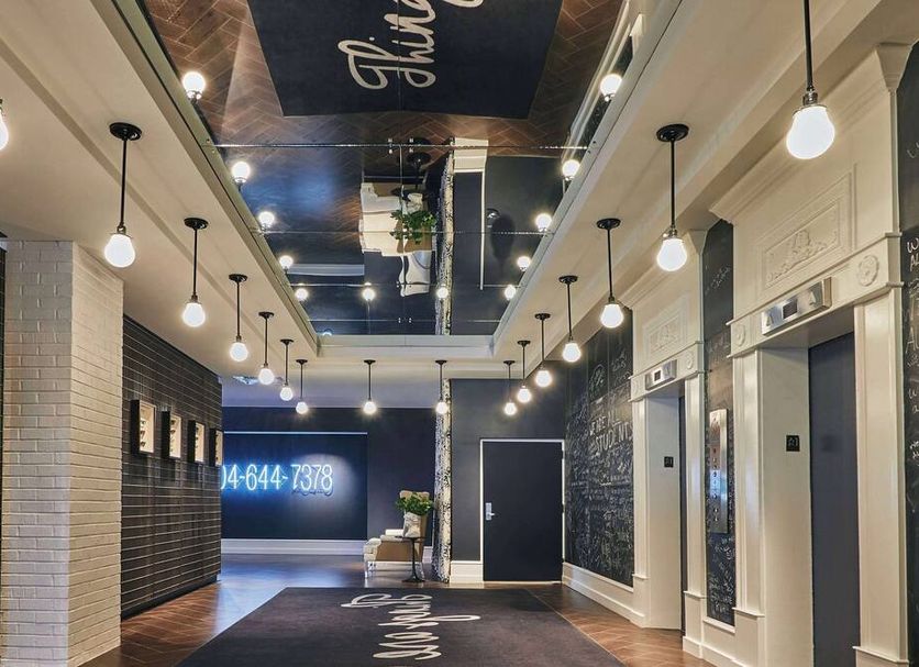 Graduate by Hilton Richmond lobby hallway with hanging globe lights and elevator doors