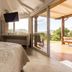 Fazenda Verde Praia do Rosa bedroom with sliding doors to a deck and scenic hillside view in Imbituba