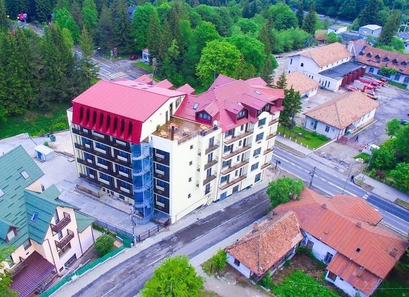 Aerial view of Hotel Piemonte in Predeal with red roofs, balconies, and surrounding trees