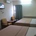 Skudai Baru Hotel in Skudai guest room with two beds, chairs, window and wall-mounted TV