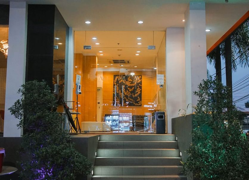 M Hotel Jakarta entrance with lit steps, glass doors, and potted plants in Jakarta