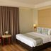 Horison Hotel Sukabumi guest room with king bed, curtains, bedside lamps, and small table