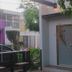 Airport X Managua hotel entrance with gray door, green wall, and outdoor seating in Managua