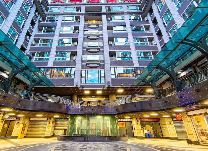 In One City Inn in Taichung City, atrium-style hotel courtyard with glass canopy and tall central tower