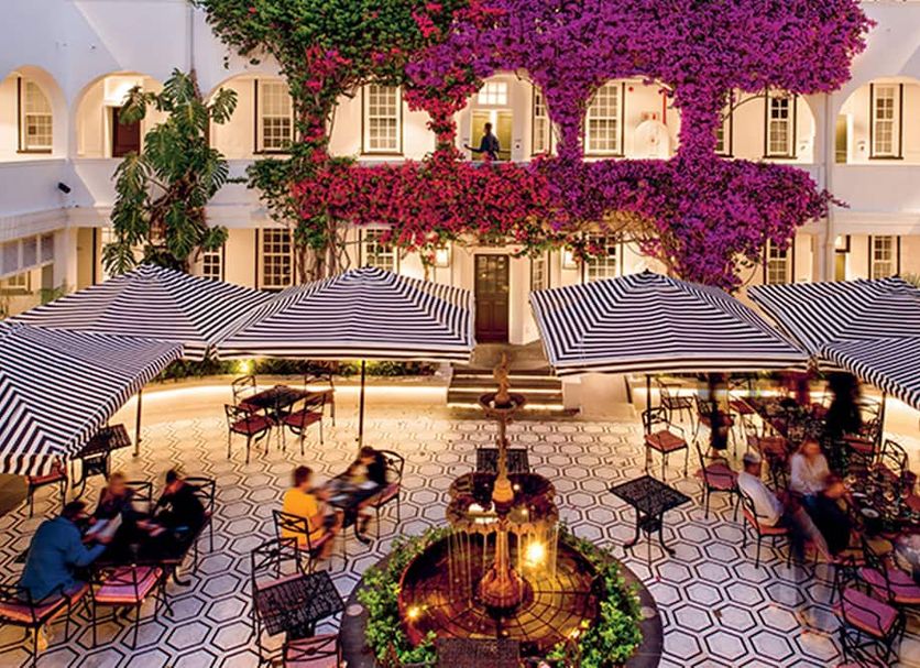 The Winchester Hotel By Newmark in Cape Town courtyard dining under striped umbrellas and bougainvillea