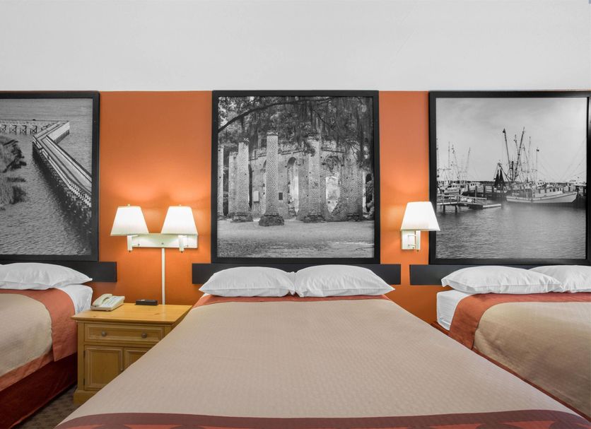Super 8 by Wyndham Port Royal/Beaufort room with three beds and black-and-white wall art