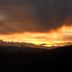 Sunset mountain view from Hotel Sumit Kausani in Kausani, with glowing orange sky over dark peaks.