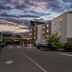 Country Inn & Suites by Radisson Princeton, WV exterior at dusk with parking lot and sunset sky