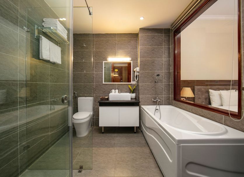 Tam Coc Nam Hoa Hotel and Spa bathroom in Ninh Binh with glass shower, bathtub, and vanity