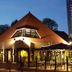Hotel Bieze in Borger at dusk, with a warmly lit outdoor terrace and steep-roofed building