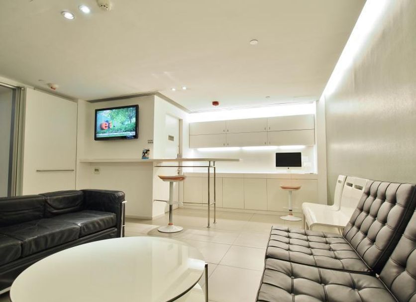 60 West Hotel, Hong Kong lounge with black and white sofas, round table, and compact bar area