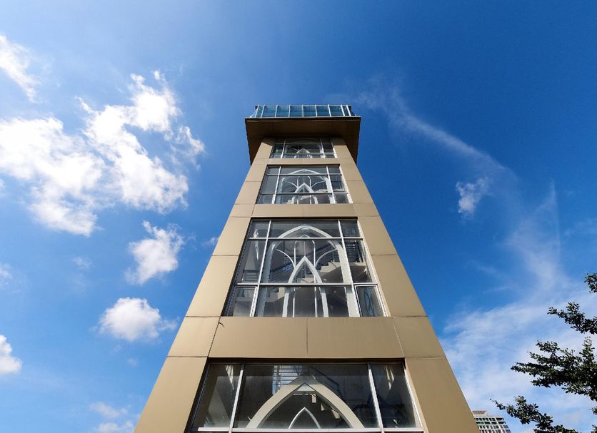 The Nagoya Plasa Redpartner in Batam, low-angle view of a tall hotel tower against a blue sky