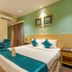 The Platinum Hotel, Hyderabad: bright hotel room with king bed, teal accents, and seating area
