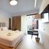 Pavo Art Hotel in Heraklion guest room with king bed, balcony door, and wall-mounted TV