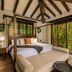 Sierra Lago in Mascota bedroom with canopy bed, wood beams, and forest-view windows