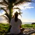 Pousada Santú Noronha in Fernando de Noronha, woman on deck facing ocean sunset with palm trees