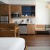 Element Austin Round Rock guest room with kitchenette, sofa, bench seating and wood flooring in Round Rock