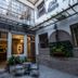 Che Juan Hostel Ba courtyard in Buenos Aires with tables, plants, and open glass doors