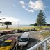 Pavilion Beachfront Apartments in Mount Maunganui with balcony view of beach, road, and parked cars