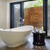 Lion Sands River Lodge in Sabie Park bathroom with freestanding tub and glass doors to a private deck