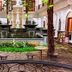 The Grand Palace Hotel Malang courtyard with fountain, balcony, and lush indoor garden in Malang