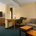 Fairfield Inn and Suites by Marriott Weirton guest room with sofa, desk and chair, and wall art