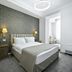 Imperial Palace Hotel Yerevan guest room with bed, bedside lamps, and patterned accent wall