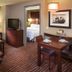 Residence Inn by Marriott Minneapolis Plymouth suite with living area, dining table, TV, and bedroom doorway