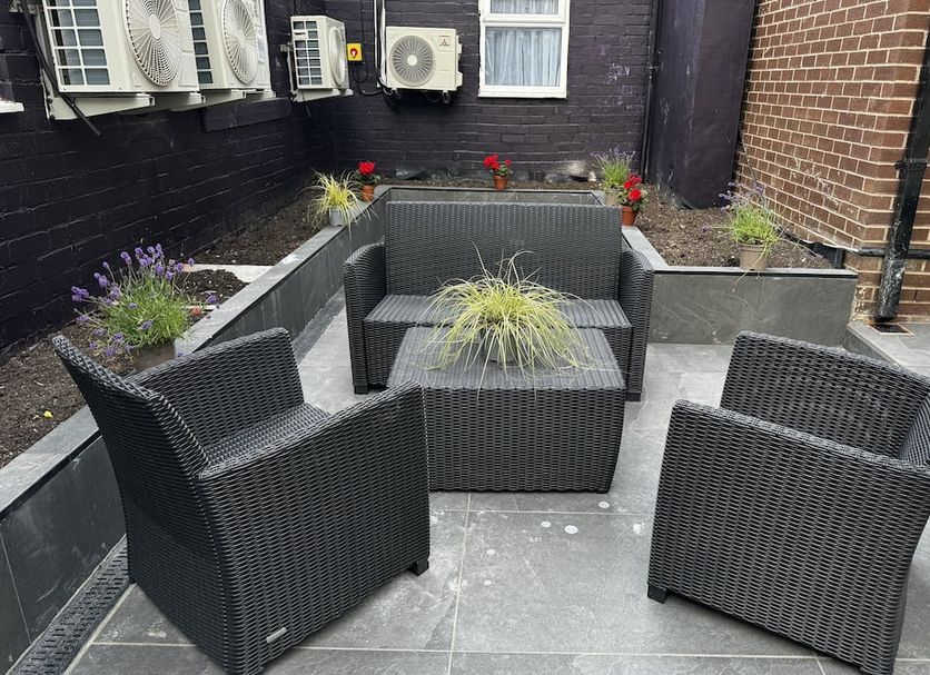The Court House, Bolton: outdoor courtyard seating with wicker chairs, table, and potted plants
