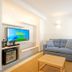 Malibu Foz Hotel in Figueira da Foz living area with sofa, TV, coffee table and window light