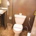 Justbeds Bangkok bathroom with sink, toilet, shower hose and trash bin