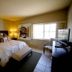 4 Seasons at Desert Breezes Palm Desert guest room with king bed, window, and TV