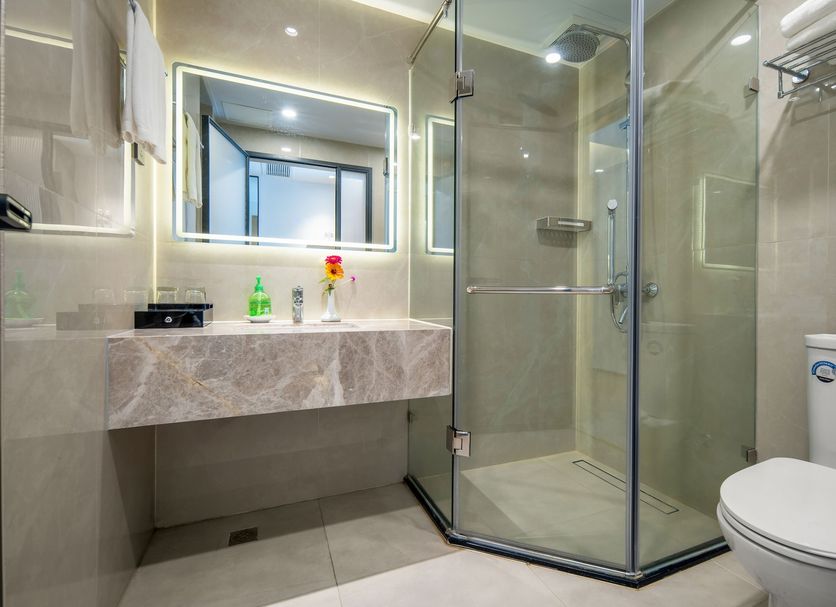 Pipaxi Hotel Zhangjiajie bathroom with glass shower, vanity sink, mirror and toilet