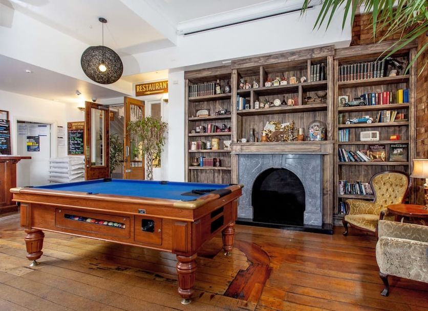 The Shakespeare Hotel Auckland lobby with pool table, fireplace and bookshelves