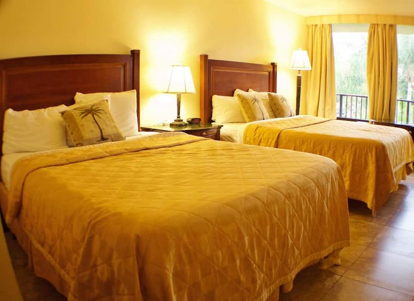 At Home Inn - Fort Pierce guest room with two double beds and window view