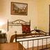 Las Iglesias Antigua guest room with wrought-iron bed, bedside lamp, and framed wall art