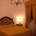 Masseria Magli Resort guest room in Martina Franca with ornate bed, lamps and draped window