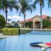 Berkley Lake Townhomes in Kissimmee with palm trees and a blue swimming pool beside townhomes