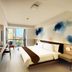 Midtown Hotel Surabaya guest room with city view, king bed, desk, and wall-mounted TV