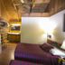 Black Bear Lodge Motel in Slade: rustic motel room with wood-paneled walls, bed, TV and mini fridge