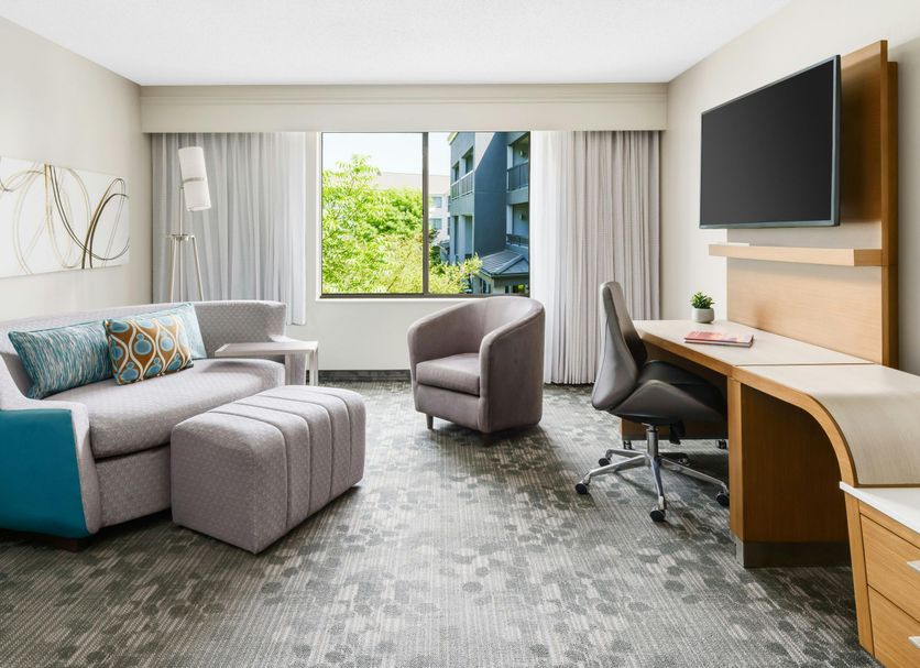 Courtyard by Marriott Dallas Lewisville guest room with seating area, desk, TV, and large window view