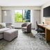 Courtyard by Marriott Dallas Lewisville guest room with seating area, desk, TV, and large window view