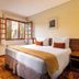Pousada Campos de Provence room in Campos do Jordão with double bed and open window view