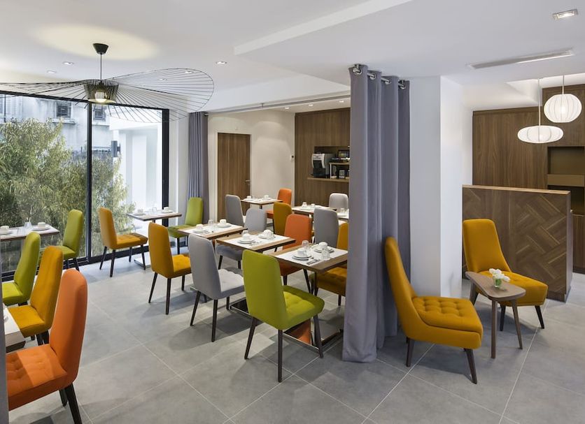Best Western Plus 61 Paris Nation Hotel dining area in Paris with colorful chairs and large windows