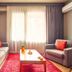 Taks-Inn Suites Istanbul living room with sofa, armchair, coffee table and large window