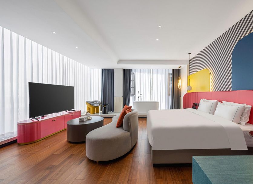Yiting Huicheng Hotel Xiamen room with bed, sofa, TV and large floor-to-ceiling windows