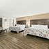 Red Roof Inn & Suites Duncan room with two beds, sofa, desk, and wood-look flooring