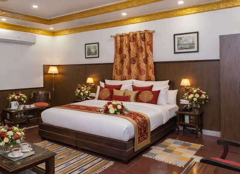 Hotel Harmony in Khajurāho guest room with king bed, floral decor, lamps and seating area