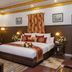 Hotel Harmony in Khajurāho guest room with king bed, floral decor, lamps and seating area